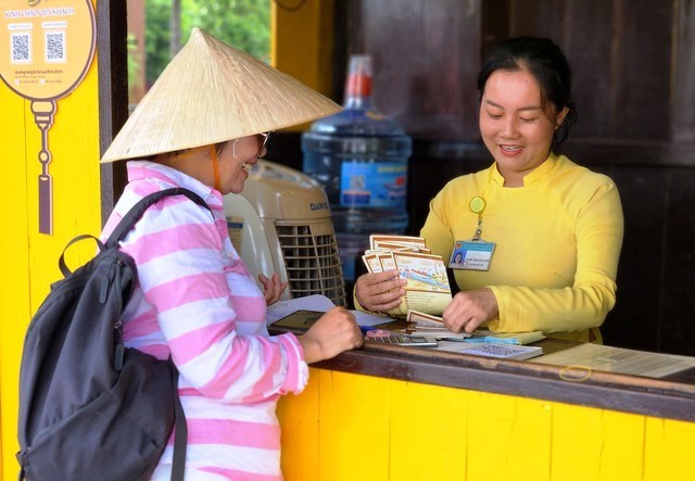 Một hướng dẫn viên mua vé cho đoàn khách trước khi vào tham quan khu phố cổ.