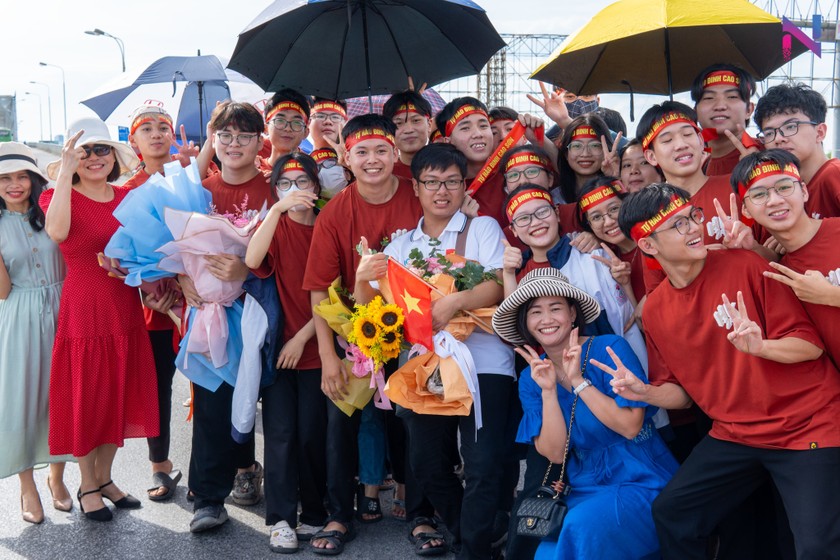 Dinh Cao Son (in white shirt holding flowers) is welcomed by relatives and classmates in Ha Tinh after winning the Gold Medal at the 2023 International Chemistry Olympiad. Photo: CHT