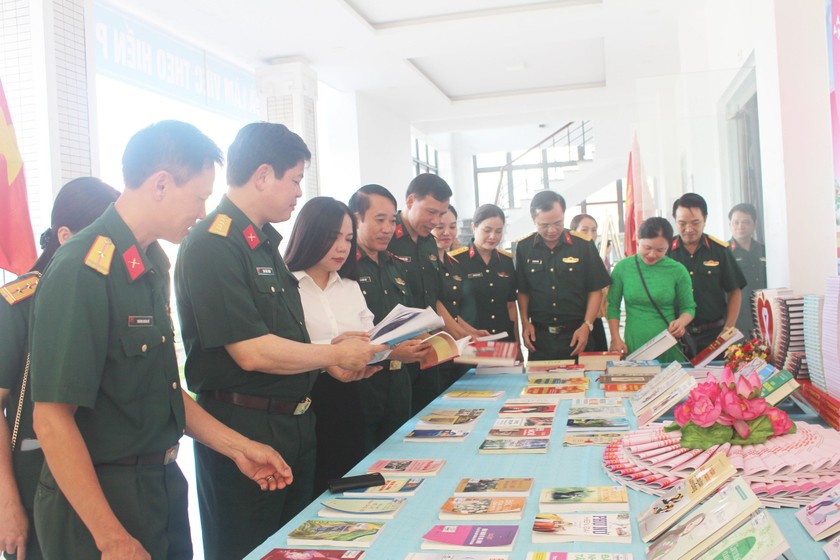 Đại biểu tham dự chương trình và xem các tài liệu tuyên truyền phòng chống bạo lực gia đình. Ảnh: PV