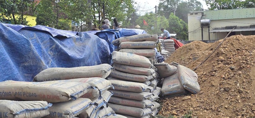 Hàng trăm tấn xi măng đông cứng vì không được bảo quản tốt được tập kết tại sân vận động xã Lộc Yên. Ảnh: Hữu Anh