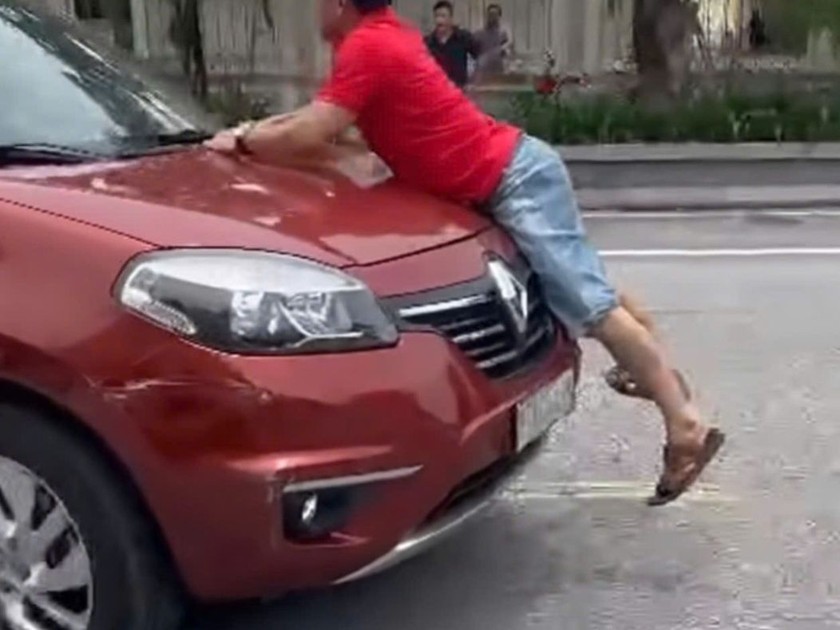 Người đàn ông bám đầu ôtô đang chạy ở TP Hà Tĩnh. Ảnh: Cắt từ clip