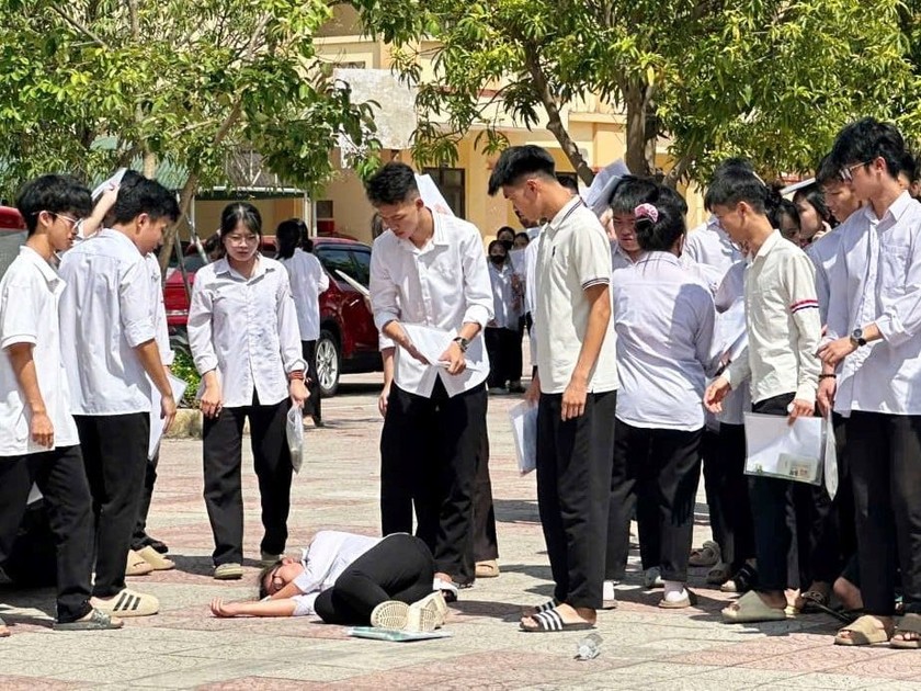 Nữ sinh ngất xỉu giữa sân trường trong thời tiết nắng nóng khiến nhiều thí sinh khác hoảng hốt. Ảnh: CTV